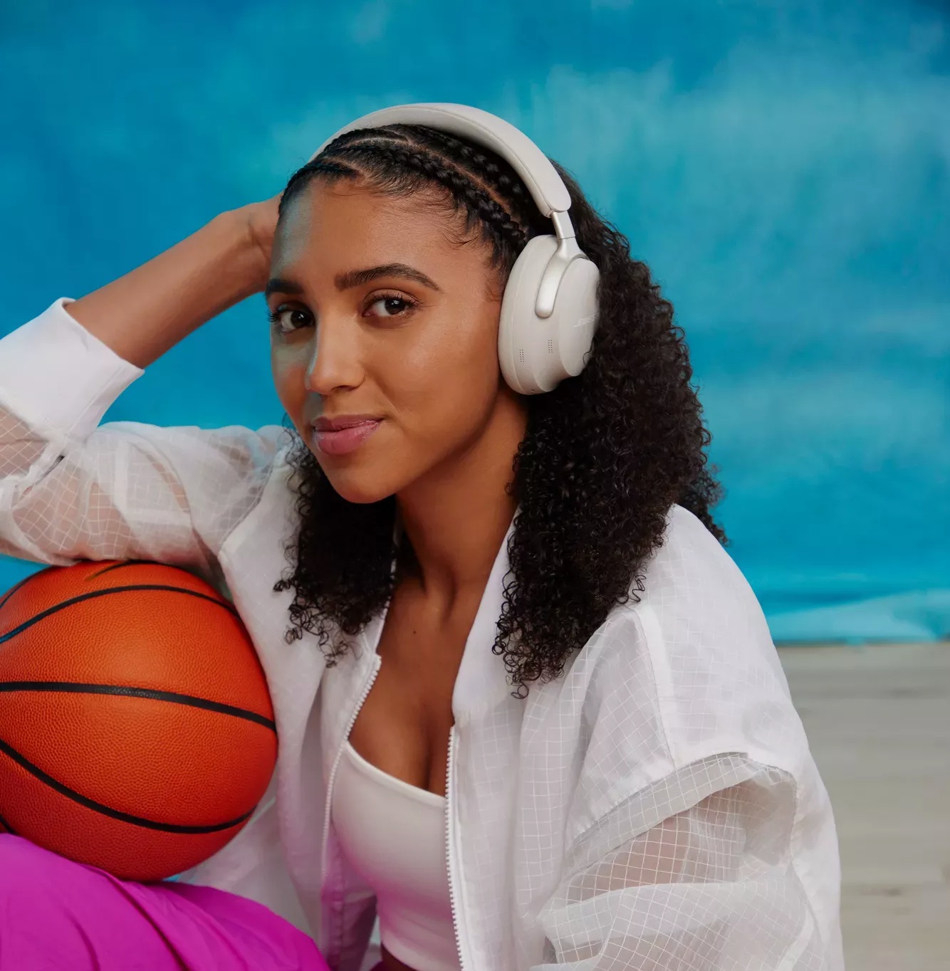 Azzi Fudd holding a basketball and wearing Bose QuietComfort Ultra Headphones