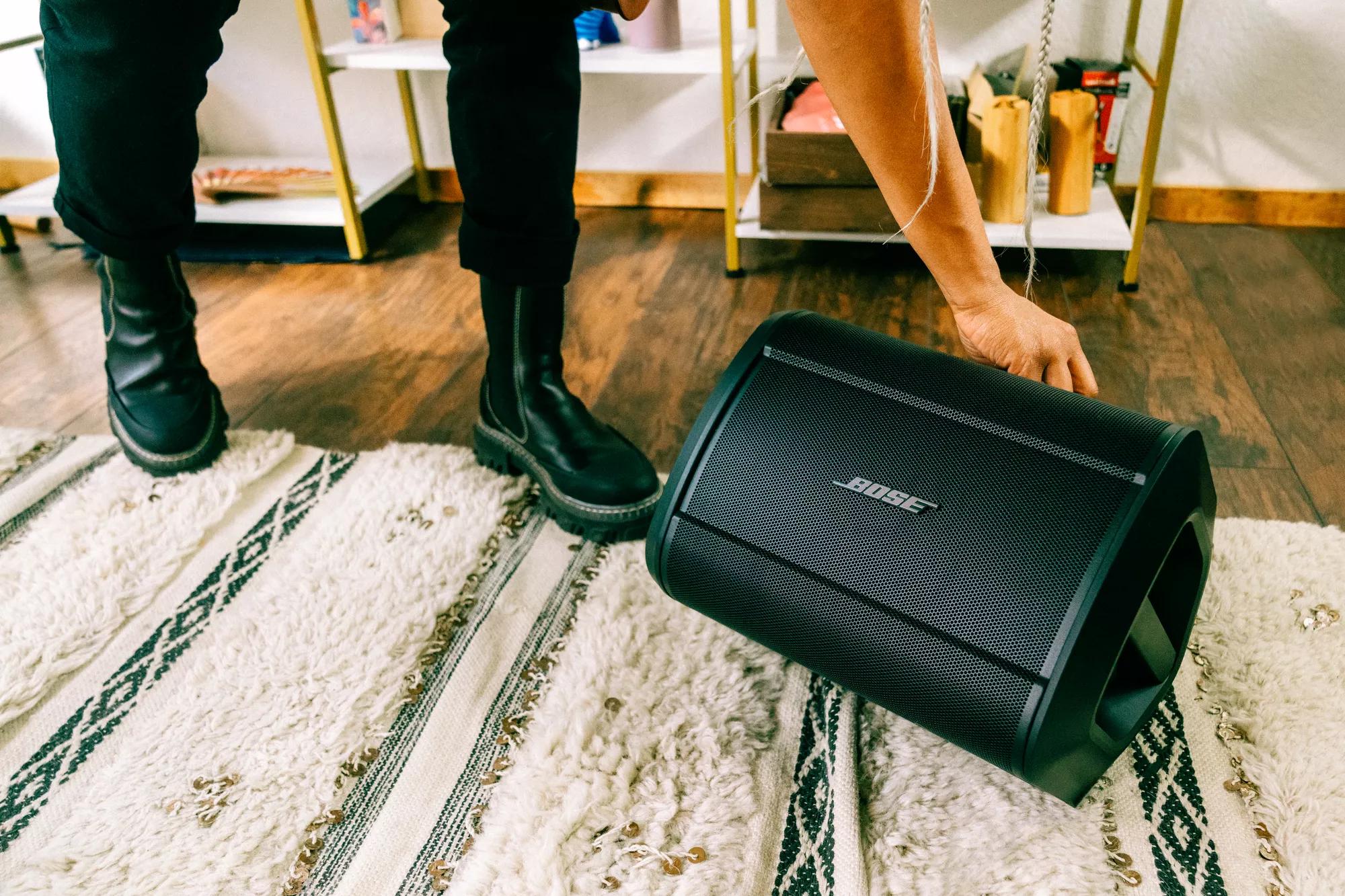 Musician adjusting the Bose S1 Pro+ Portable Bluetooth Speaker System