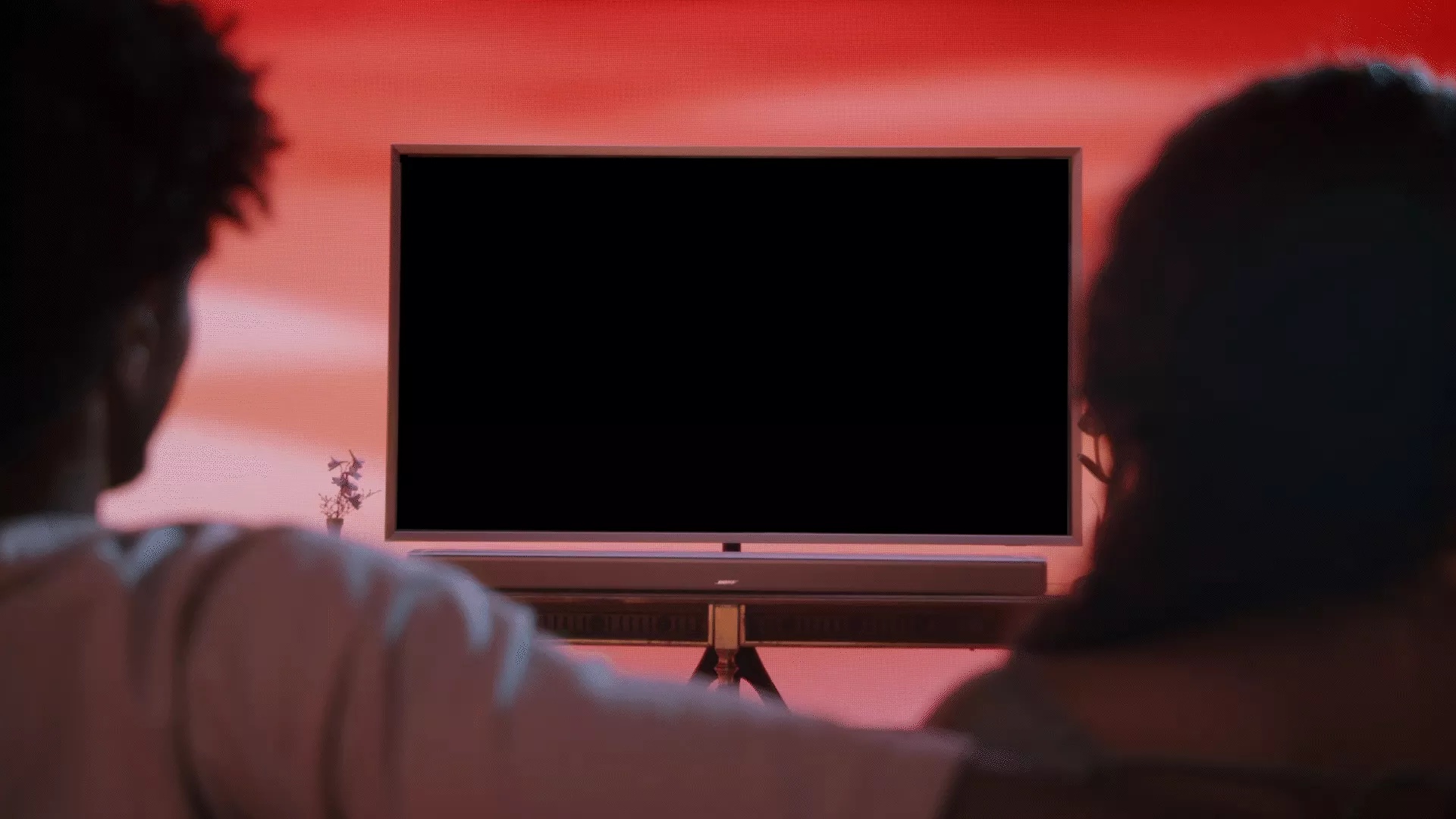 Un couple regardant la télévision avec sa barre de son intelligente Bose Ultra