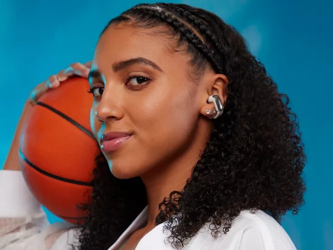 Azzi Fudd wearing Bose Ultra Open Earbuds while holding a basketball 