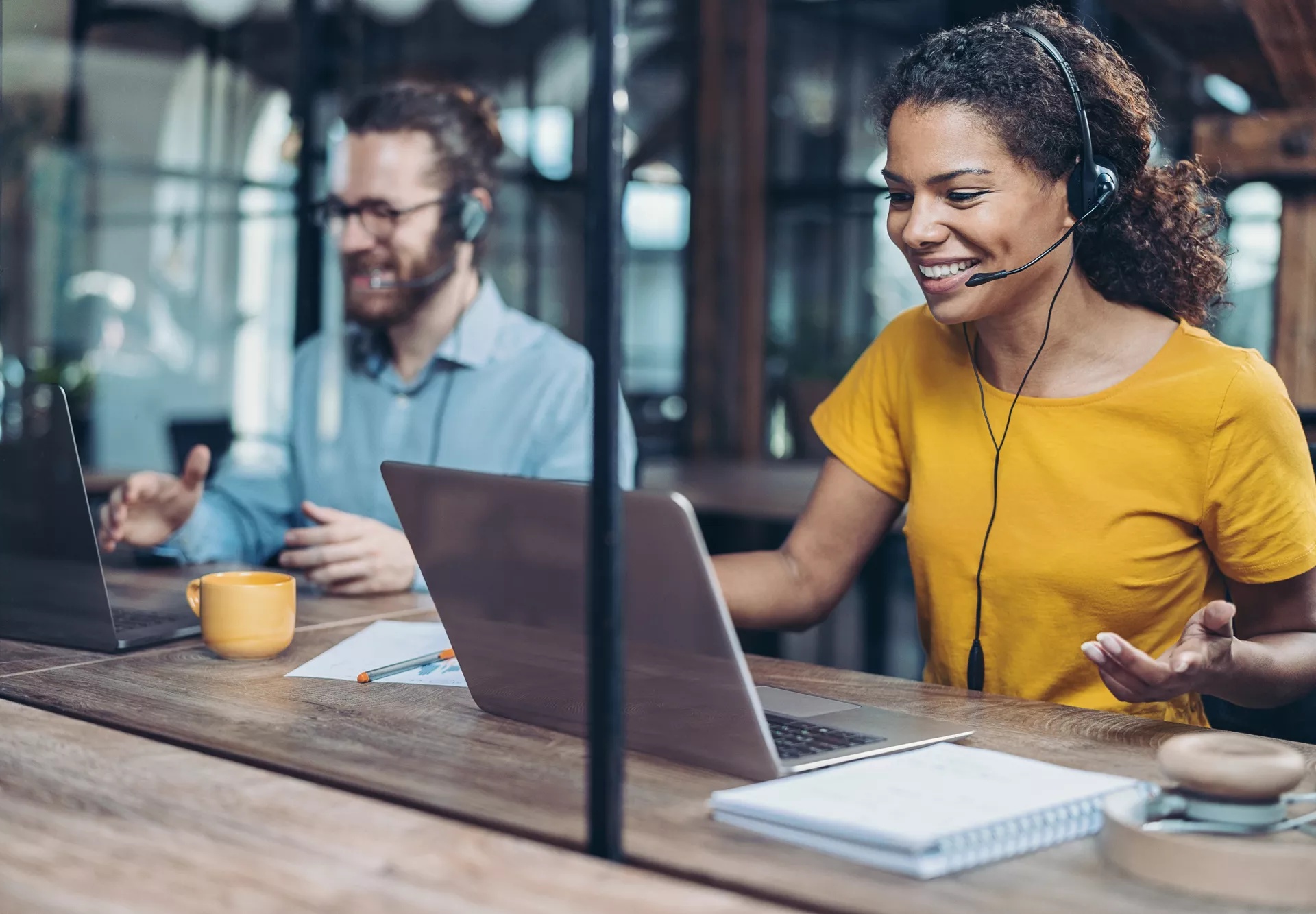 Two customer service agents at computers on call with customers.