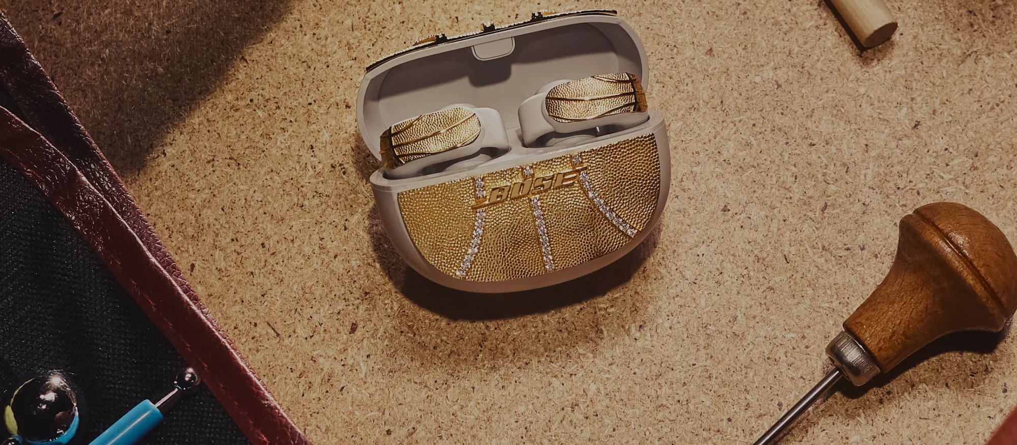 Exclusive gold-and-diamond encrusted pair of Bose Ultra Open Earbuds on the design table