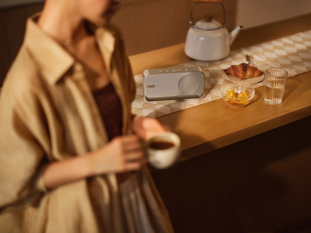 Bose SoundLink Home standing in a table with a person passing through