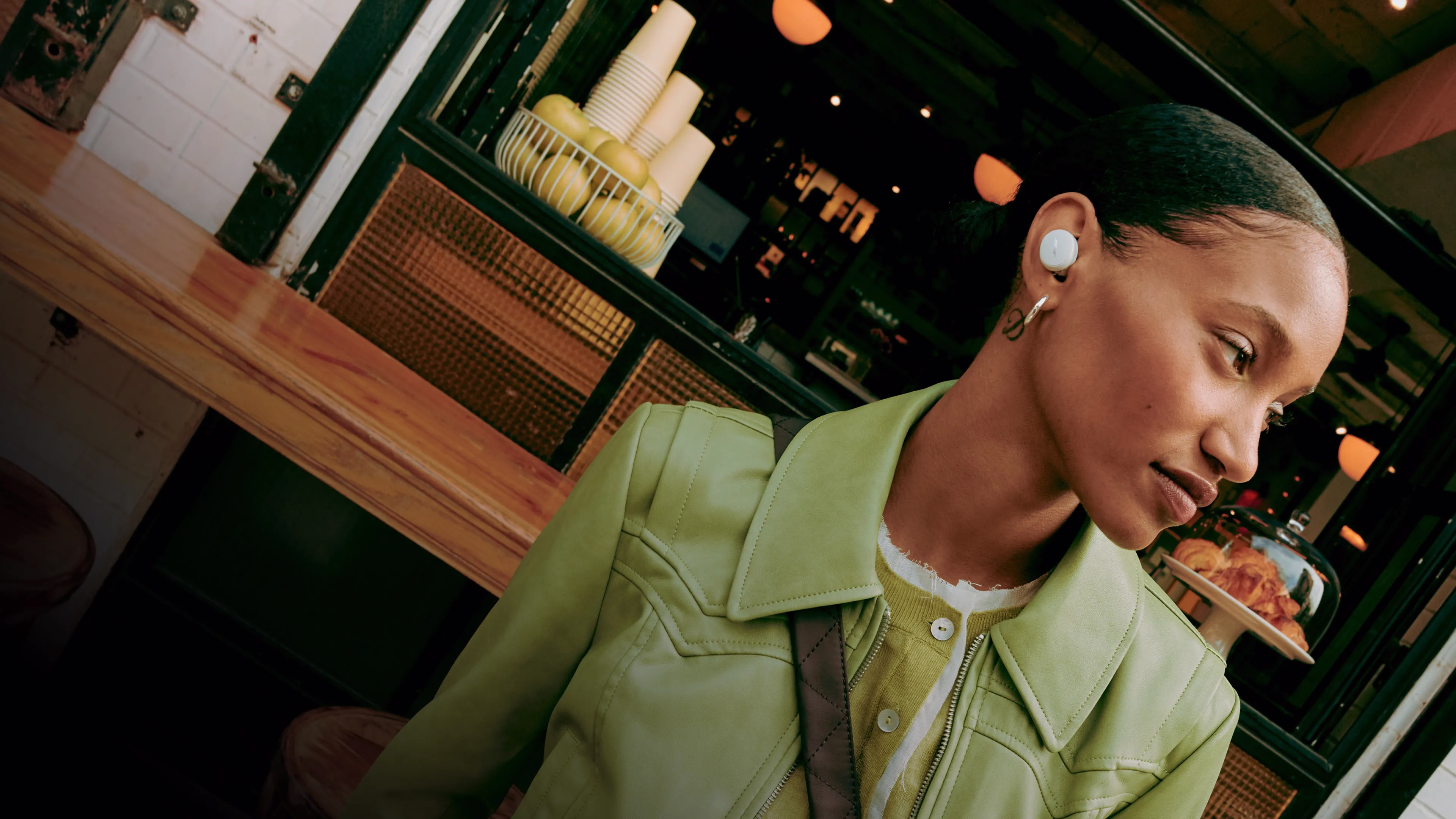 Eine junge Frau mit den Bose QuietComfort Earbuds im Freien.