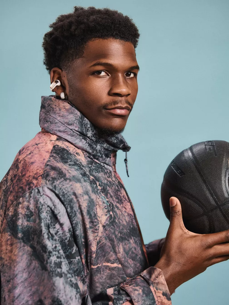 Anthony Edwards wearing Bose Ultra Open Earbuds and holding a basketball