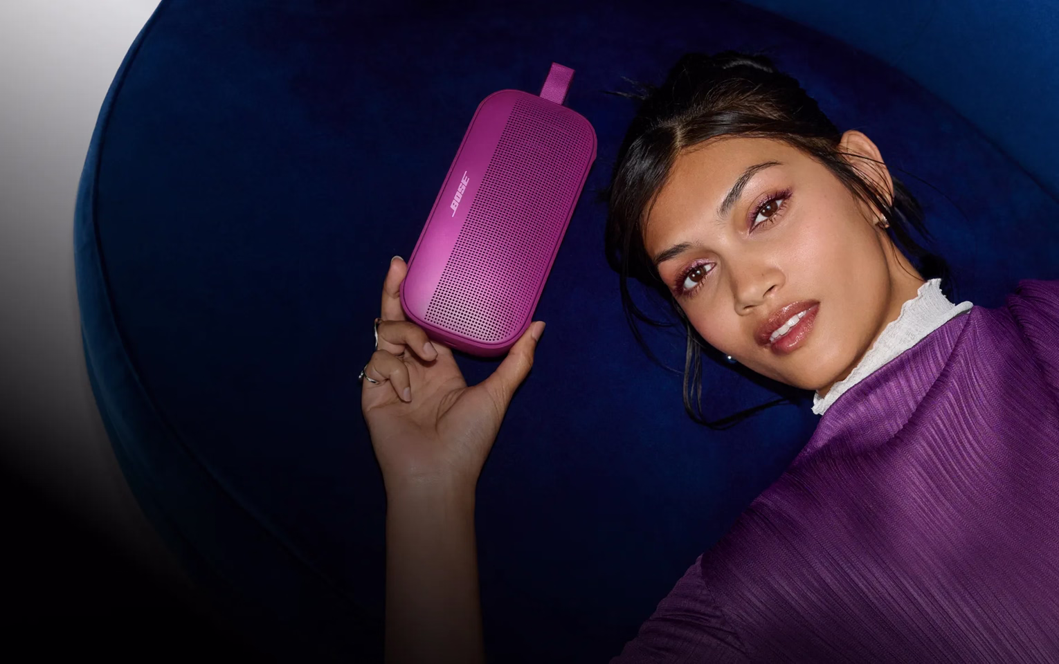 Woman holding a Bose SoundLink Flex Portable Speaker (2nd Gen) in Rosewood Mauve.