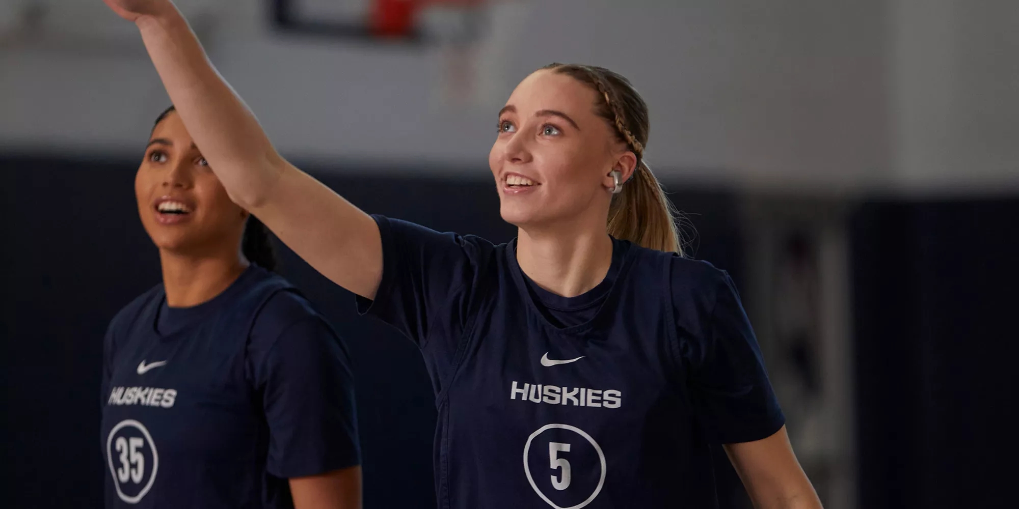 Azzi Fudd and Paige Bueckers (taking a shot) on the basketball court