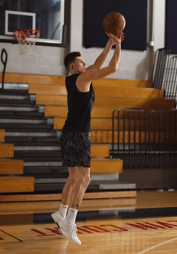 Tyler Herro wearing Bose Ultra Open Earbuds while taking a shot at the basket