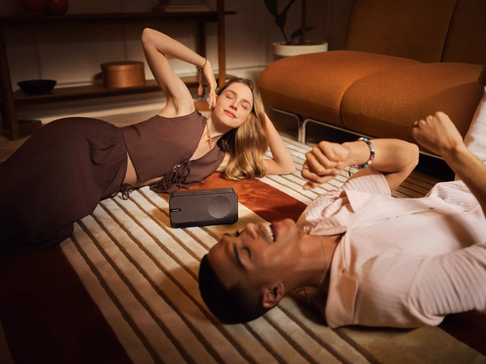 A woman and a man listening music in a room with Bose SoundLink Home 