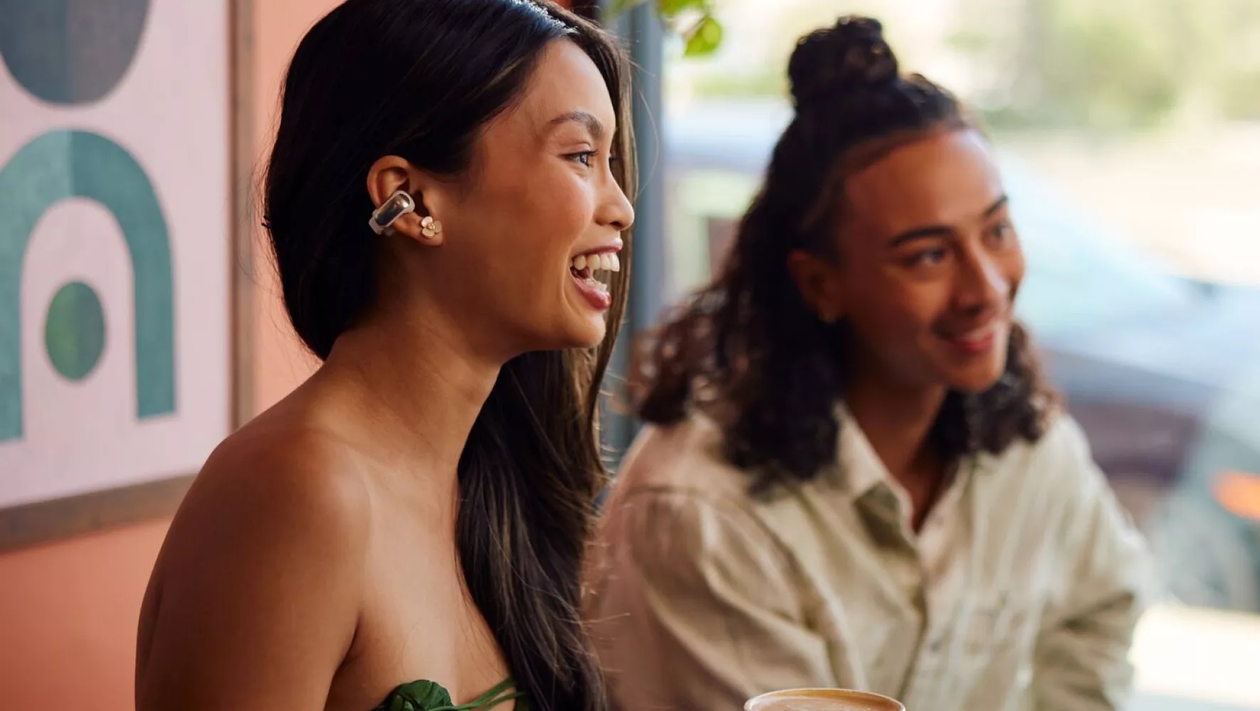 People in a meeting at a café wearing Bose Ultra Open Earbuds