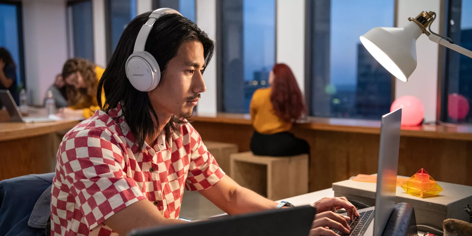Man working in an office wearing QuietComfort Headphones