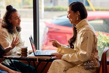 Des gens participant à une réunion dans un café et portant des écouteurs oreilles libres Bose Ultra