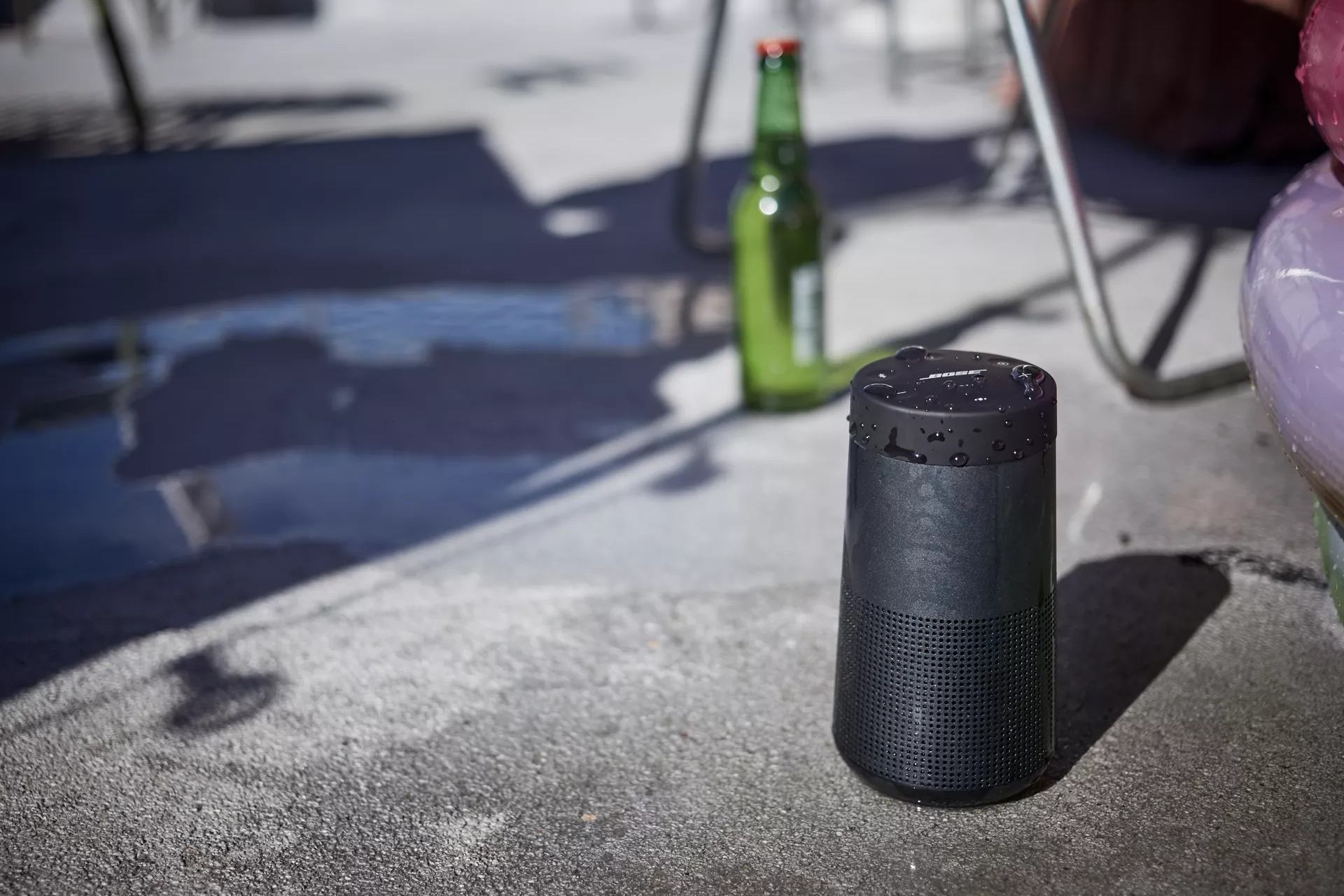 SoundLink Revolve II Bluetooth Speaker on the ground near a pool 