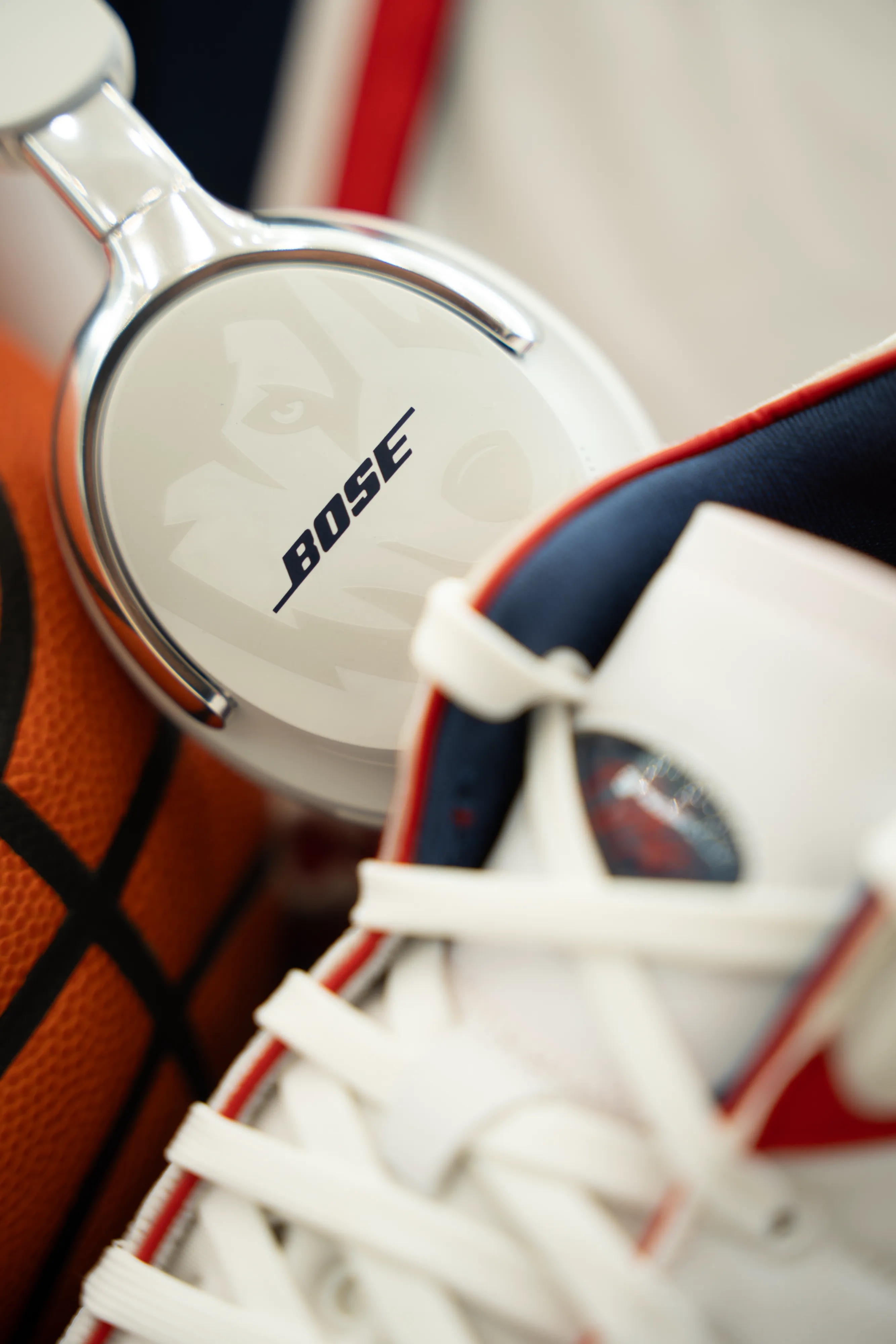 UConn x Bose QuietComfort Ultra Headphones with a basketball and sneakers.