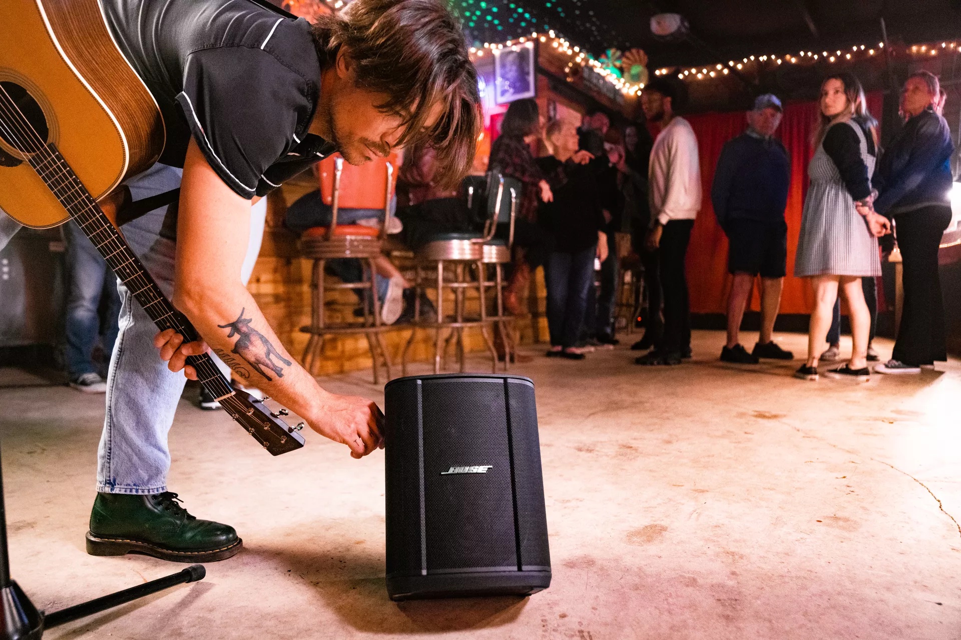 Man adjusting the bass of the Bose S1 Pro+ Portable Bluetooth Speaker System 