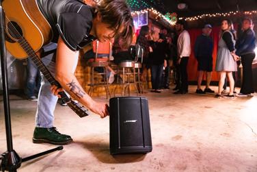 Guitarist adjusting the Bose S1 Pro+ Portable Bluetooth Speaker System