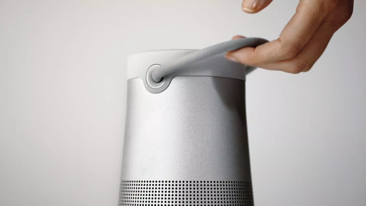 Person grabbing a SoundLink Revolve+ II Bluetooth speaker by the handle