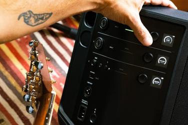 Musician adjusting bass levels on Bose S1 Pro+ Portable Bluetooth Speaker System