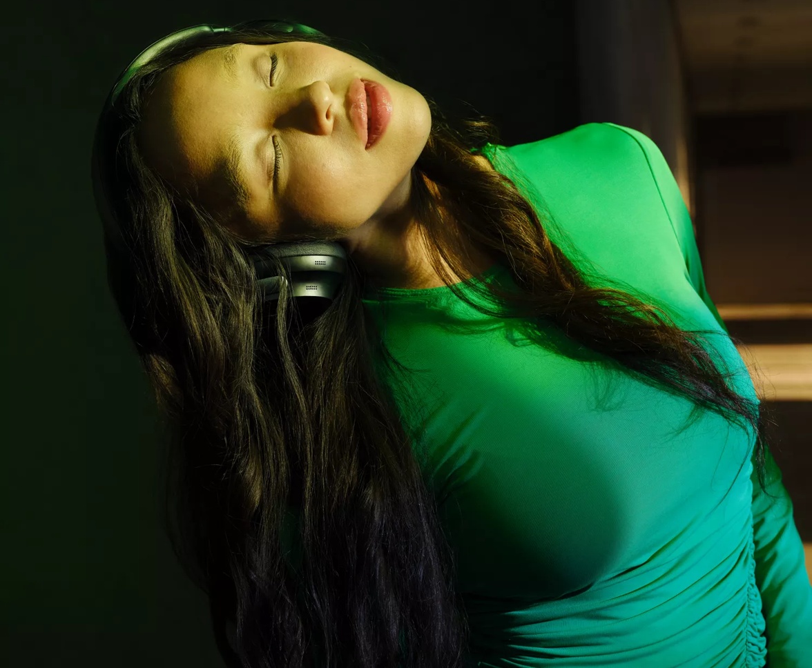 Girl closing eyes and listening to music with Bose QuietComfort Ultra Headphones