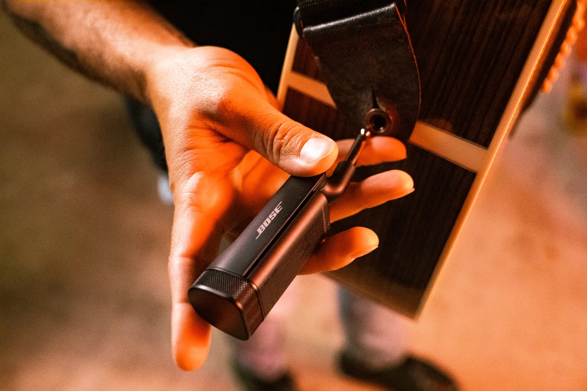 Musician attaching Bose Wireless Instrument Transmitter 1/4" (6 mm) to his guitar