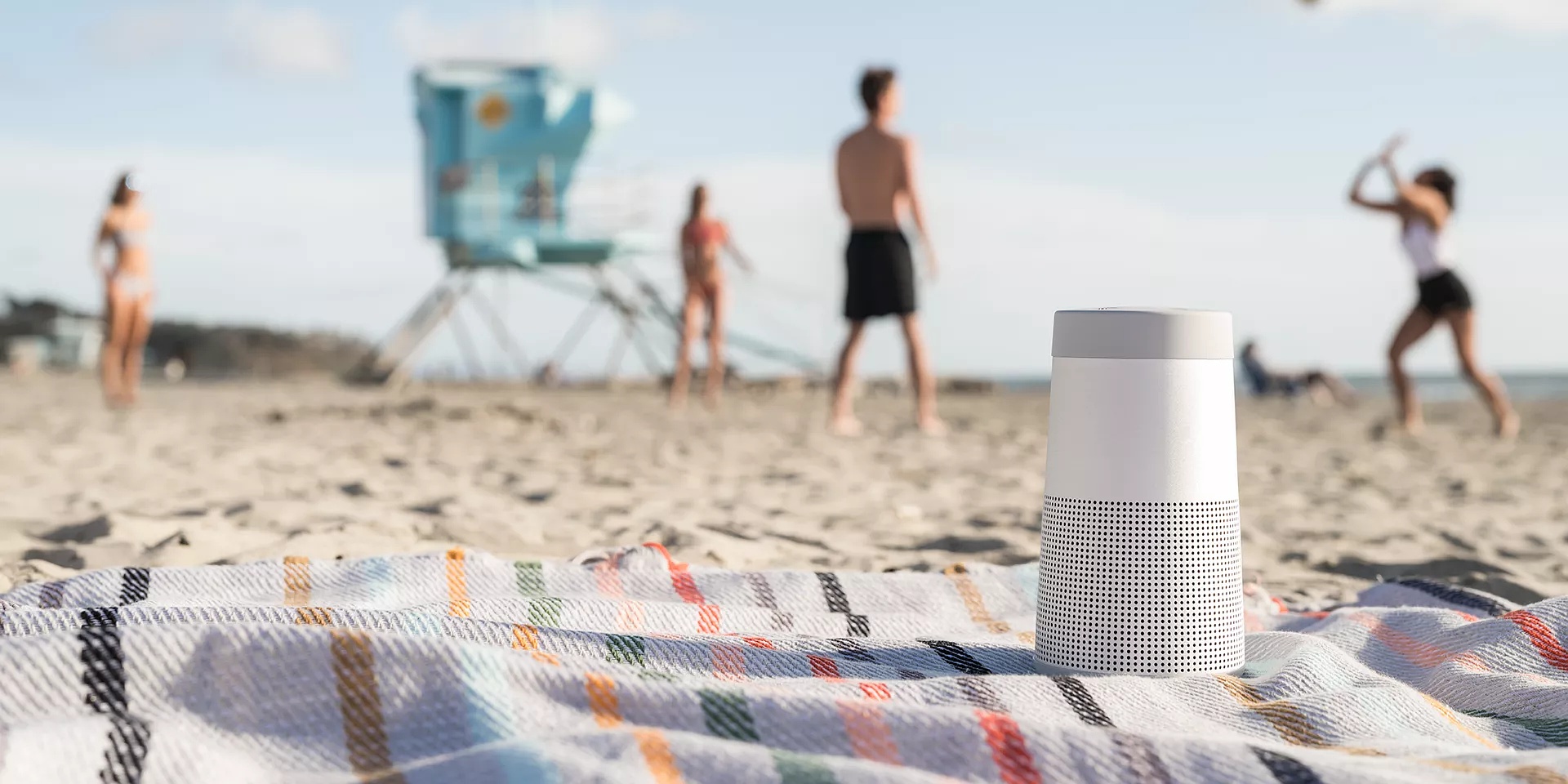 SoundLink Revolve II Bluetooth Speaker on a blanket at the beach