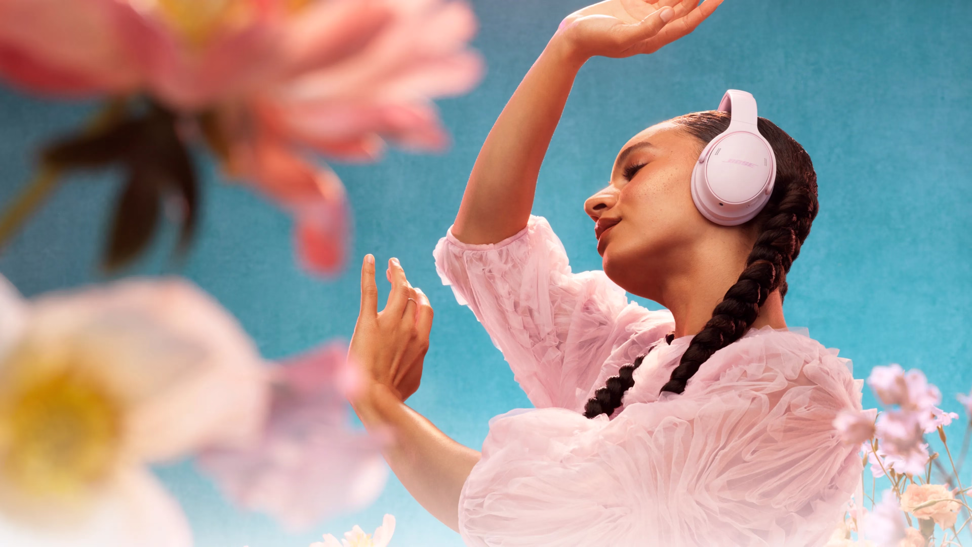 Woman wearing Bose QuietComfort Headphones in Petal Pink.