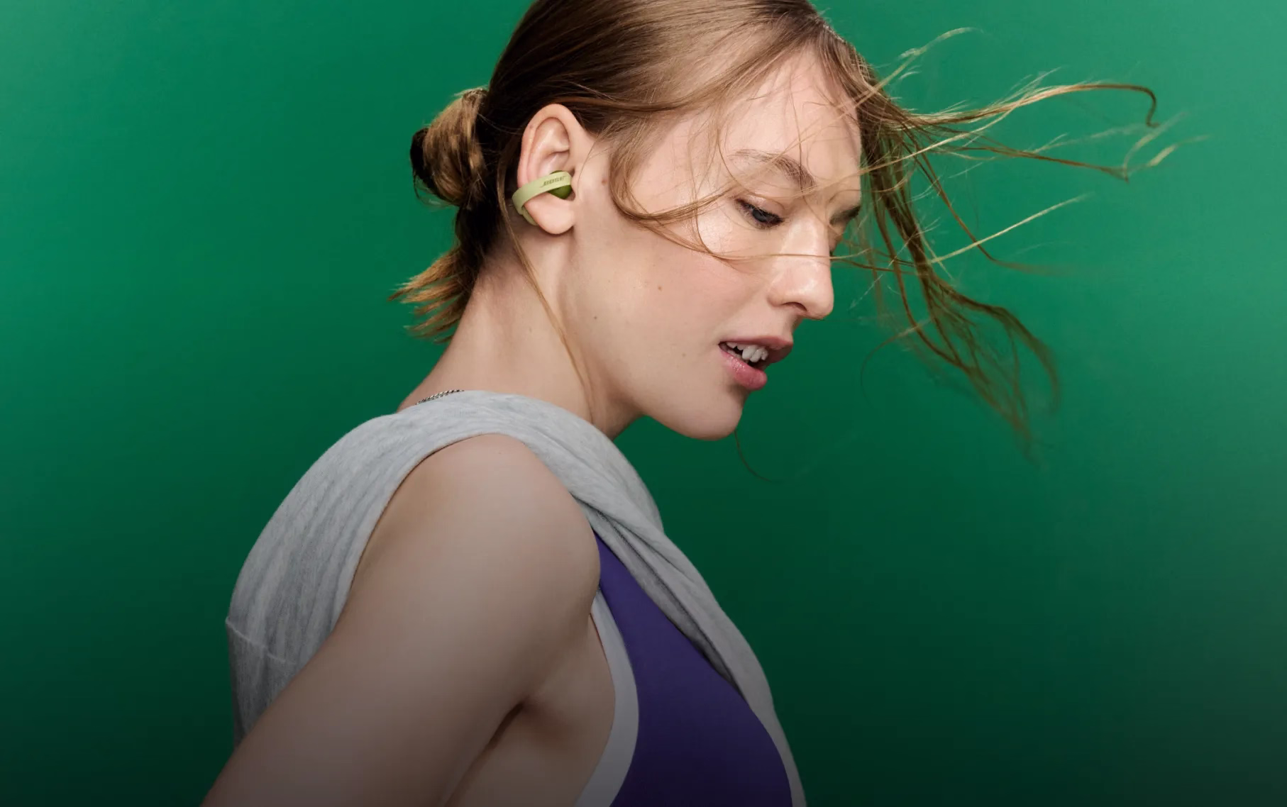 Woman wearing Bose Sport Open Earbuds while working out.