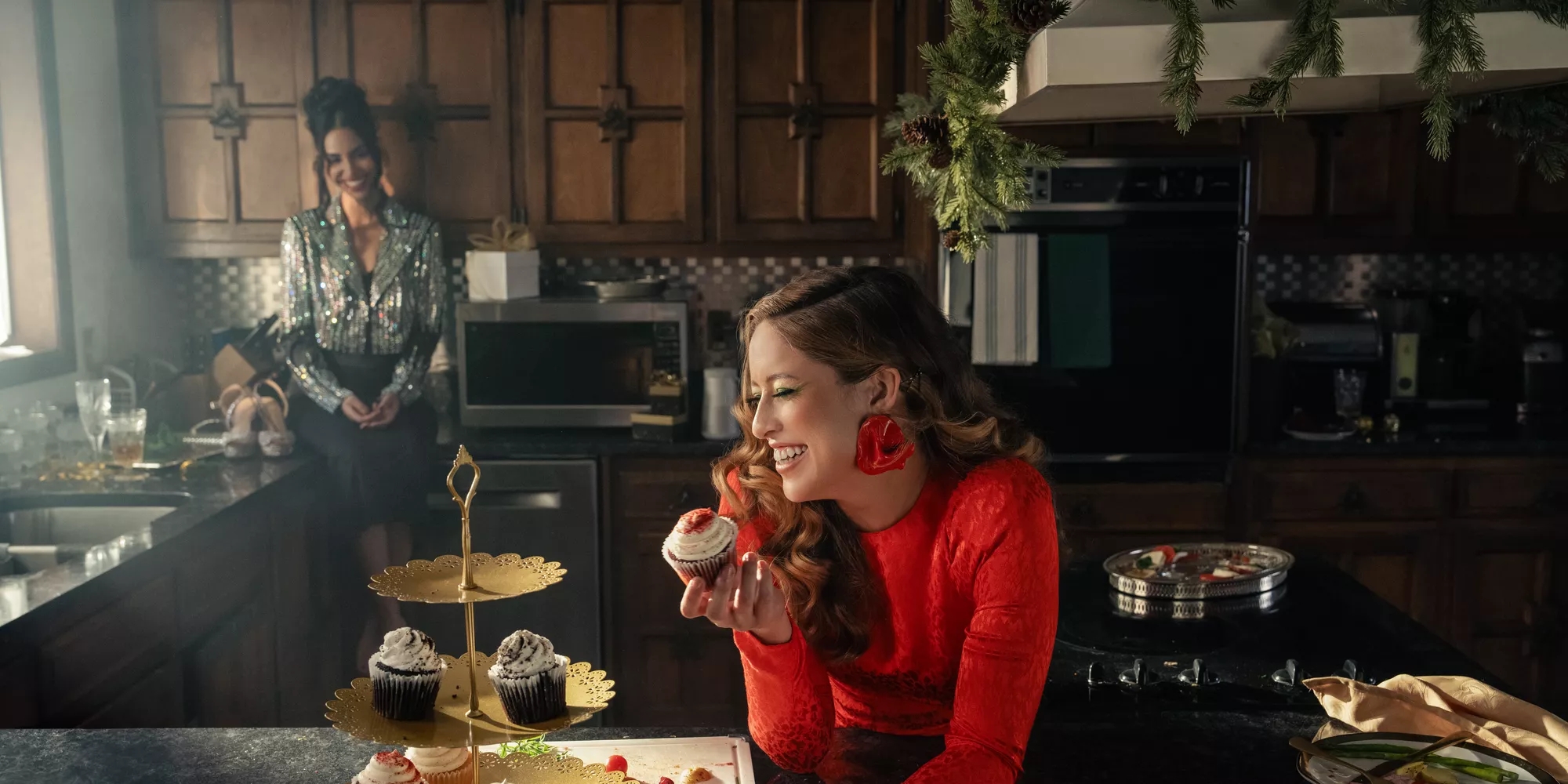 Deux femmes dans une cuisine après une célébration des Fêtes, écoutant de la musique depuis une enceinte Bluetooth Bose SoundLink Revolve+ II