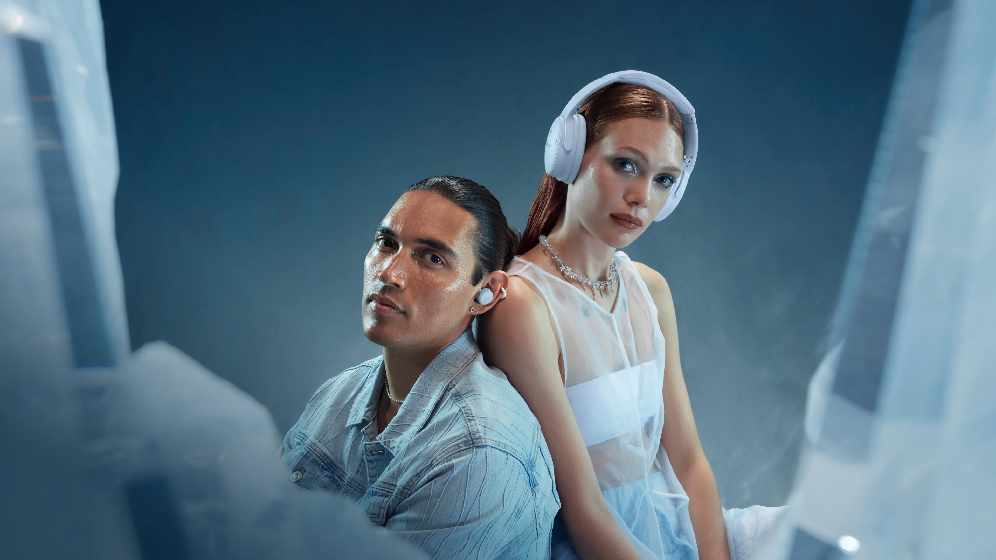 Man wearing Bose Ultra Open Earbuds and woman wearing QuietComfort Ultra Headphones (2nd Gen) in Ice Blue.