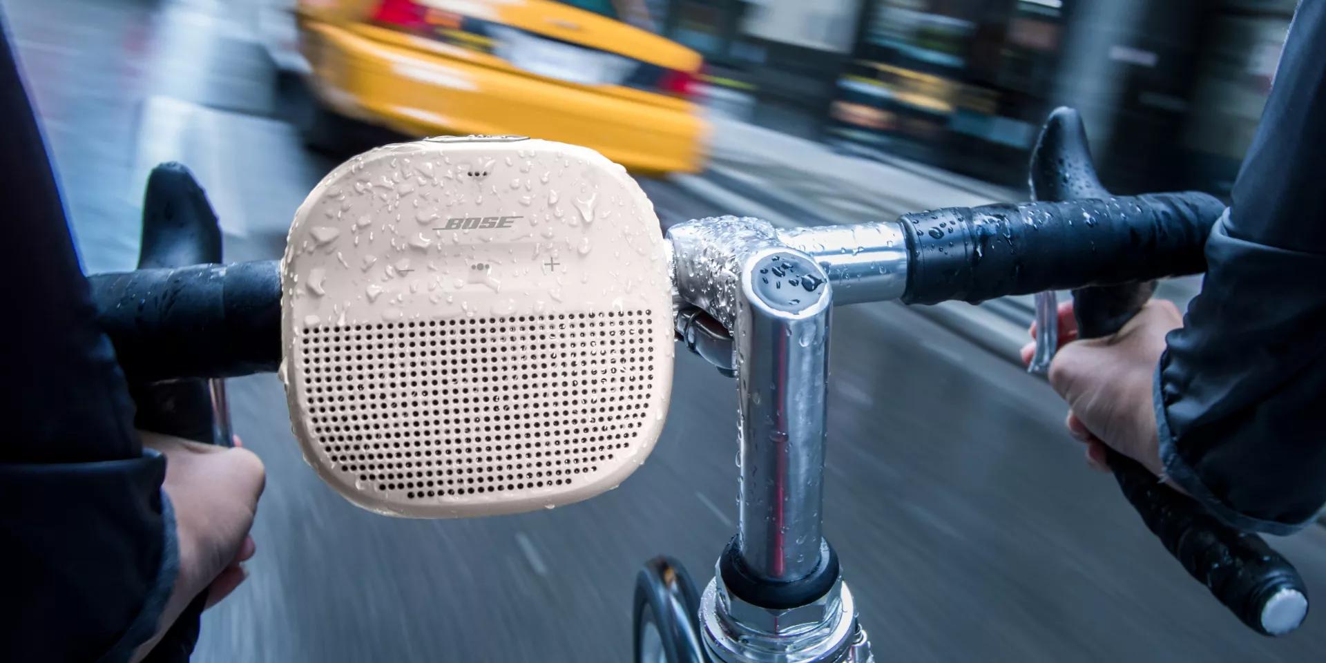 Enceinte Bluetooth SoundLink Micro en blanc fumé attachée à un guidon de vélo