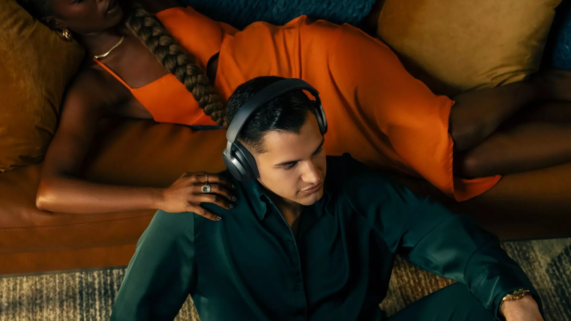 A man sitting on the floor of his living room wearing Bose QuietComfort Ultra Headphones