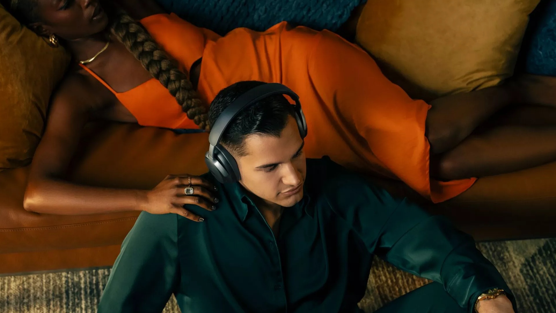 A man sitting on the floor of his living room wearing Bose QuietComfort Ultra Headphones
