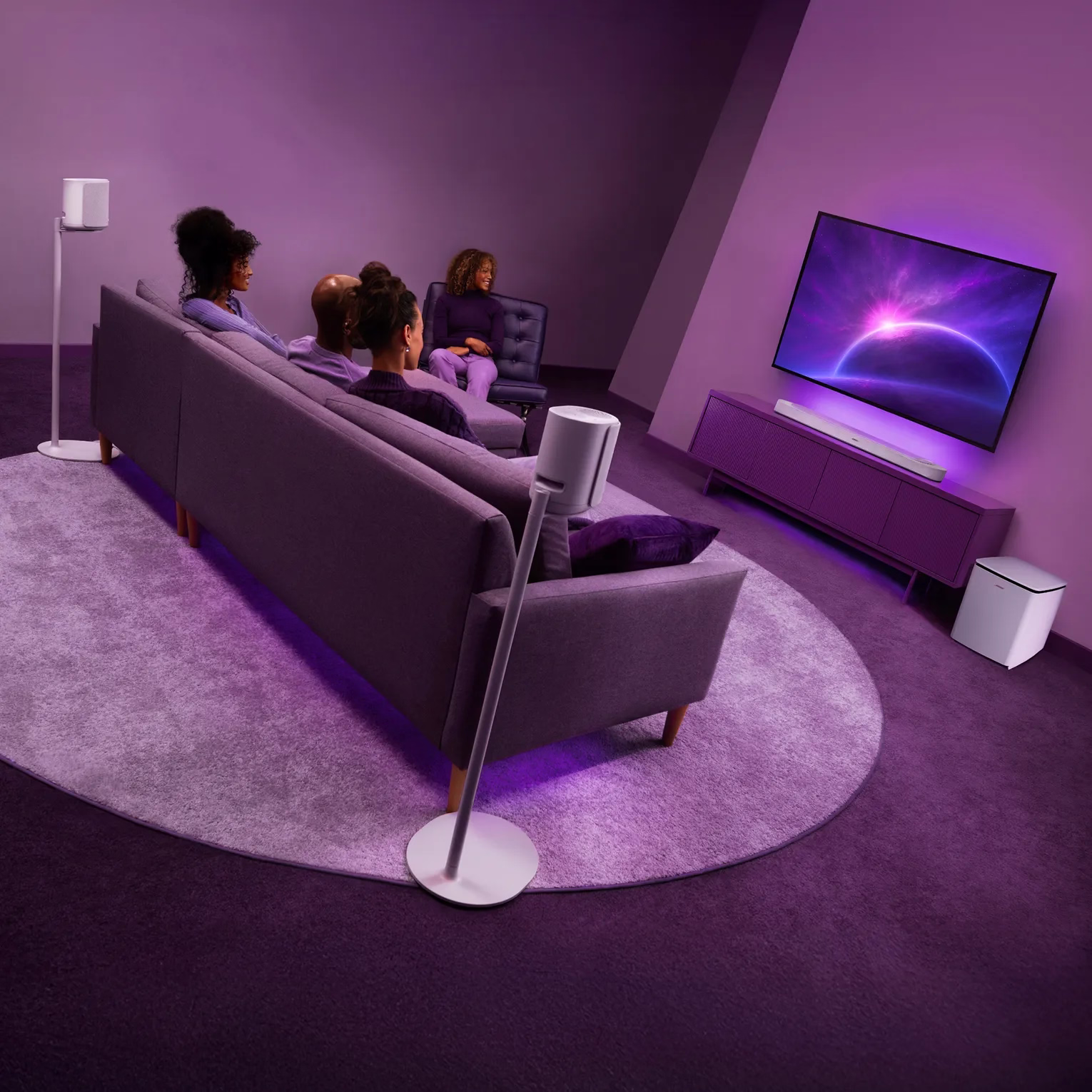 リビングルームでテレビを楽しむ友人たち。システムはBose Lifestyle Ultra Soundbar、ソファの後ろにフロアスタンド付きのLifestyle Ultra Speaker、そしてLifestyle Ultra Subwooferで構成されている。