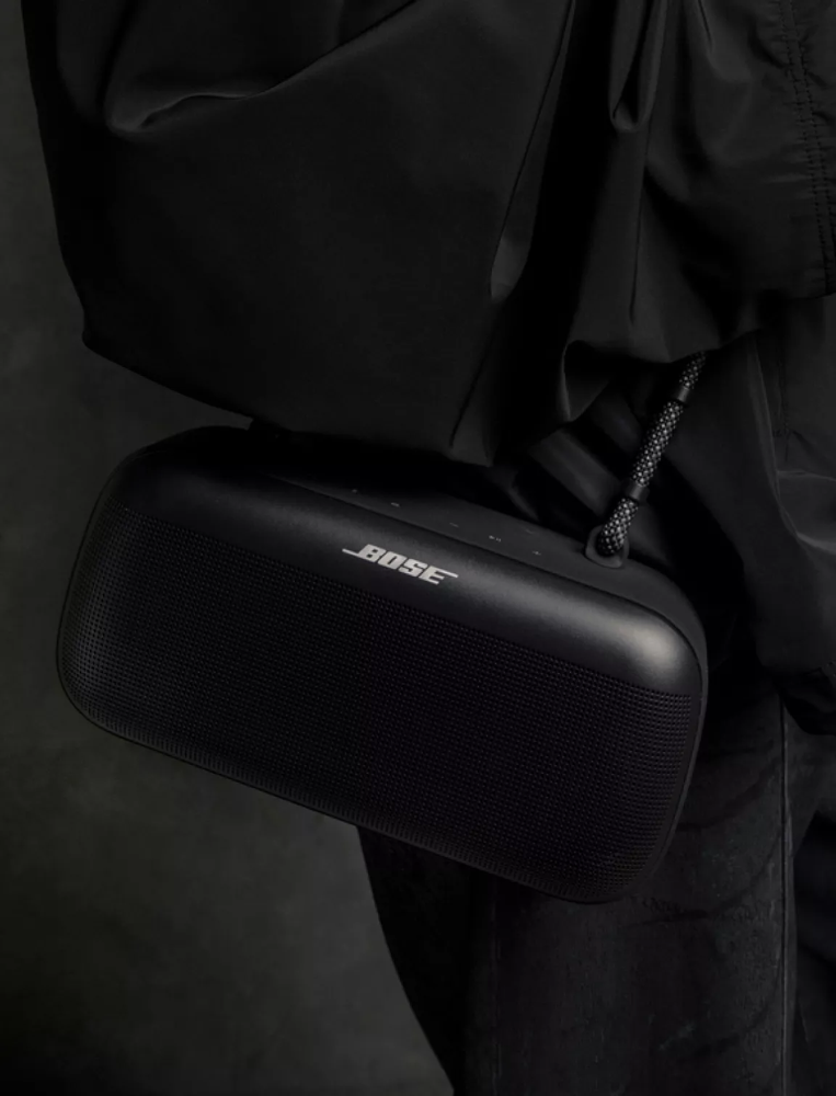 John Summit carrying a Bose SoundLink Max Portable Speaker using the carrying strap