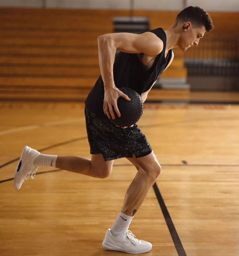 Tyler Herro dribblant avec un ballon de basketball, tout en portant ses écouteurs oreilles libres Bose Ultra