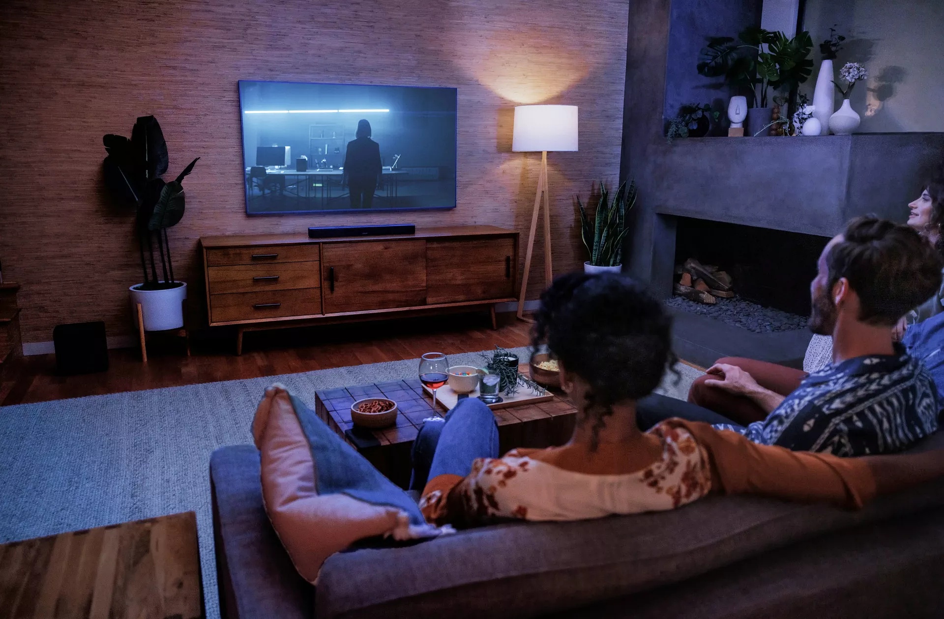 Un couple regardant la télévision dans un salon avec une barre de son Bose Smart Soundbar 600