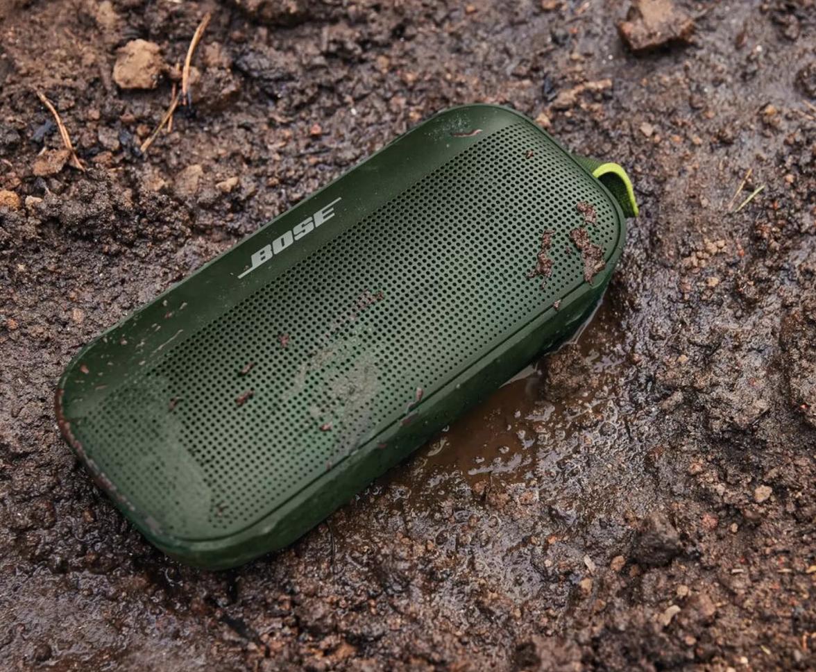 Waterproof Bose SoundLink Flex Bluetooth Speaker sitting in wet mud