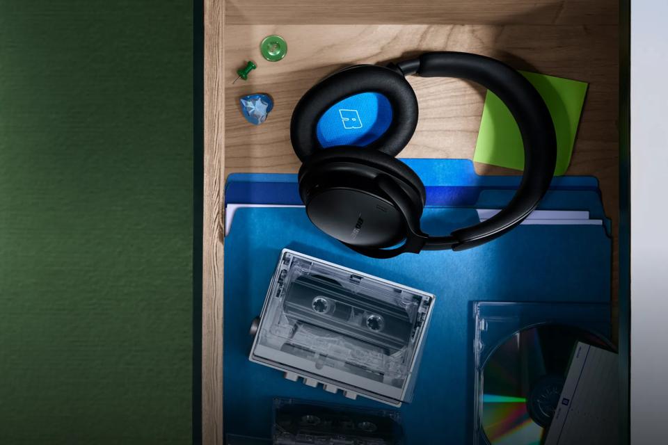 Bose QuietComfort Headphones (2nd Gen) in a desk drawer with a file folder, cassette, CDs and sticky note pad.