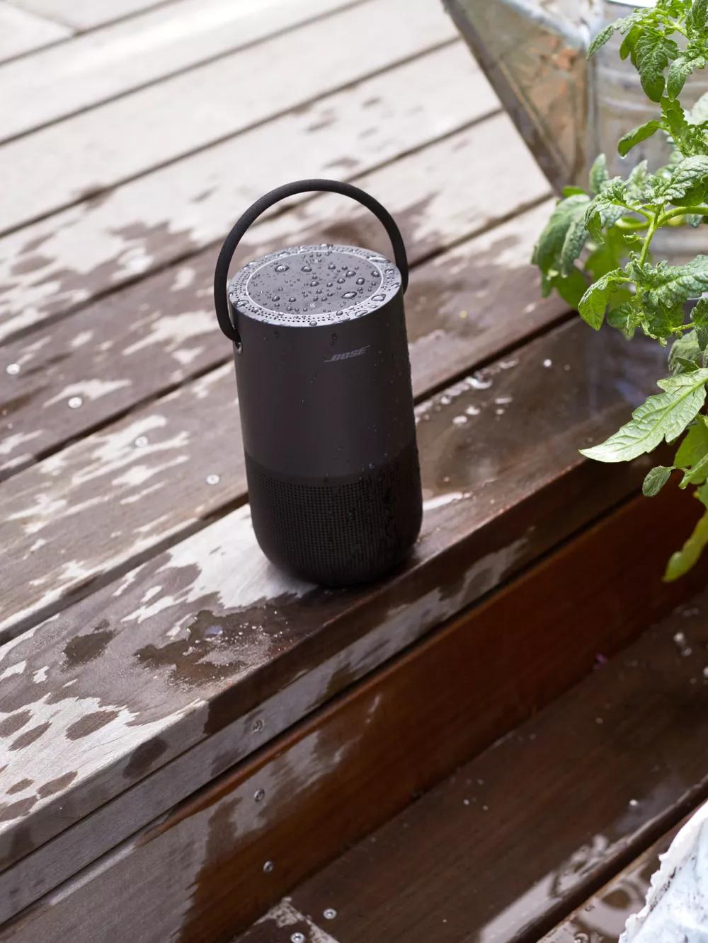 Bose Portable Smart Speaker on a deck next to a tomato plant