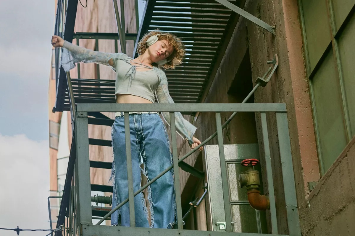 Woman wearing Bose QuietComfort Headphones outside on a fire escape