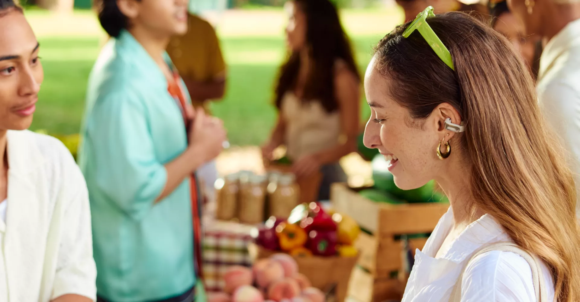 Woman wearing Bose Ultra Open Earbuds at a farmer’s market