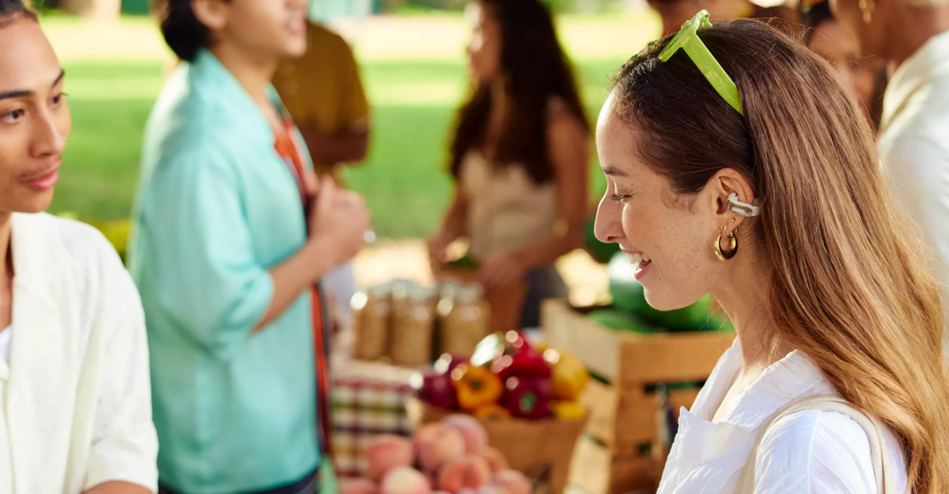 Femme portant des écouteurs oreilles libres Bose Ultra dans un marché fermier