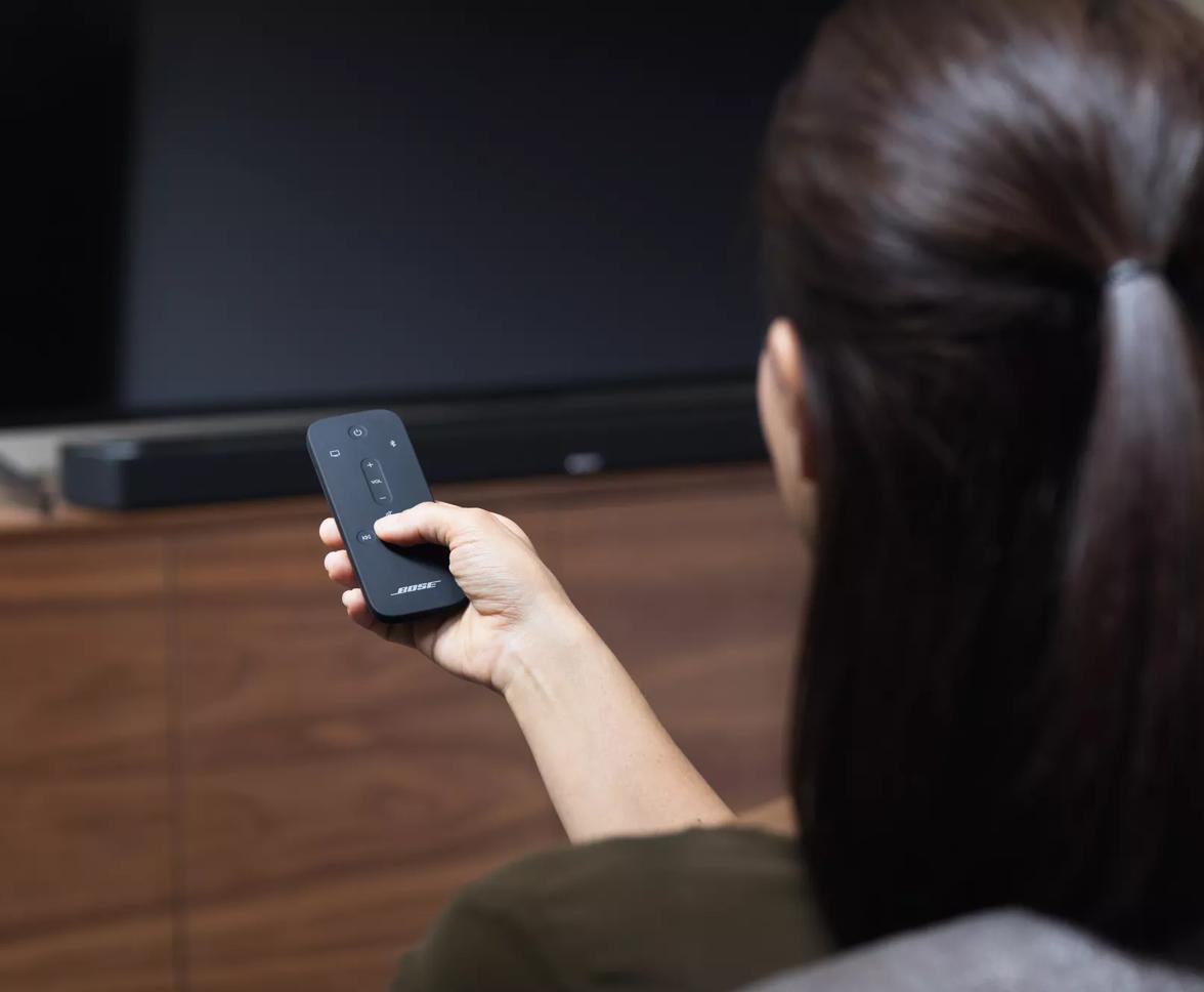 Woman in a living room holding a remote