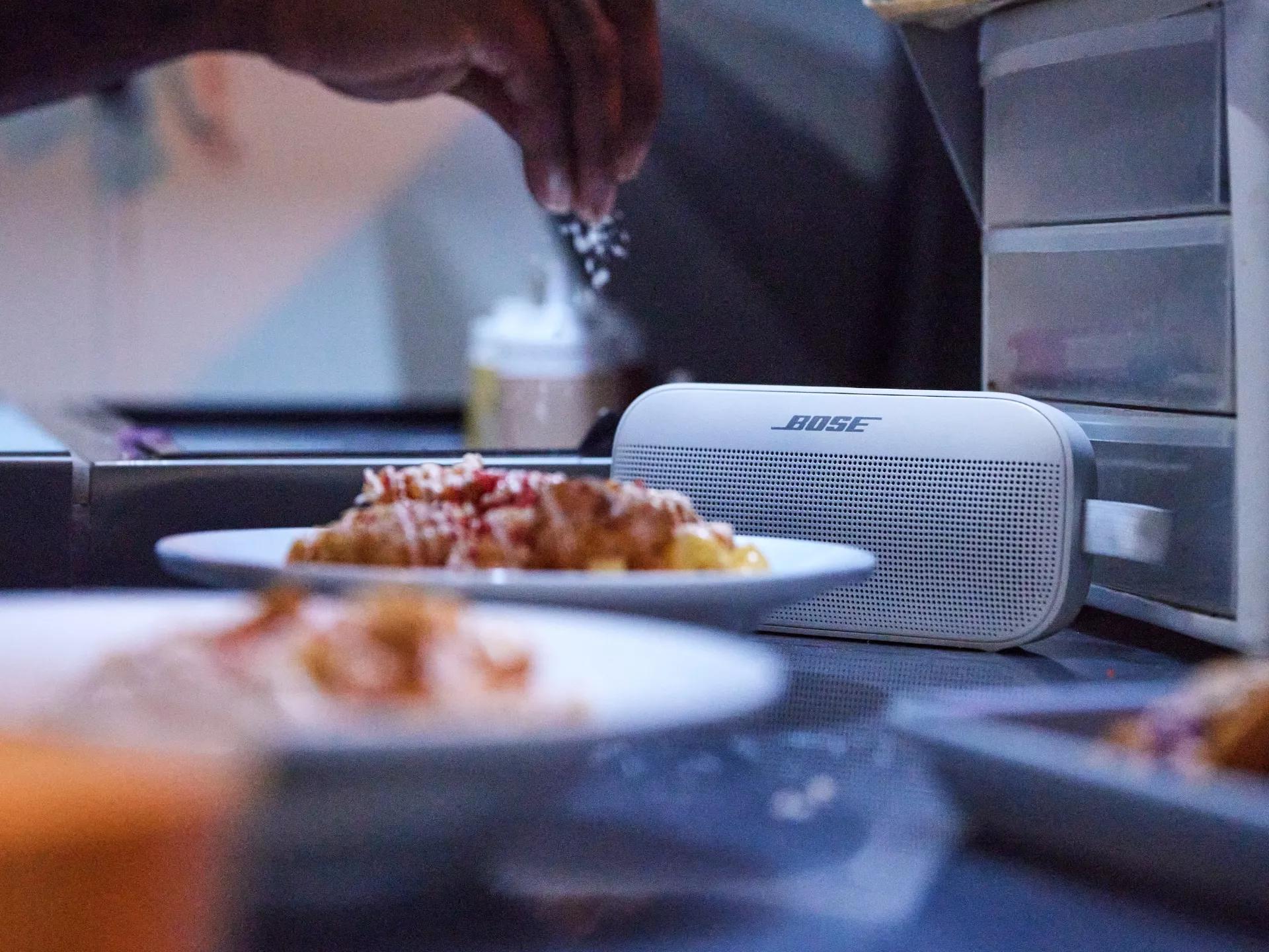 SoundLink Flex Bluetooth speaker on a table with food