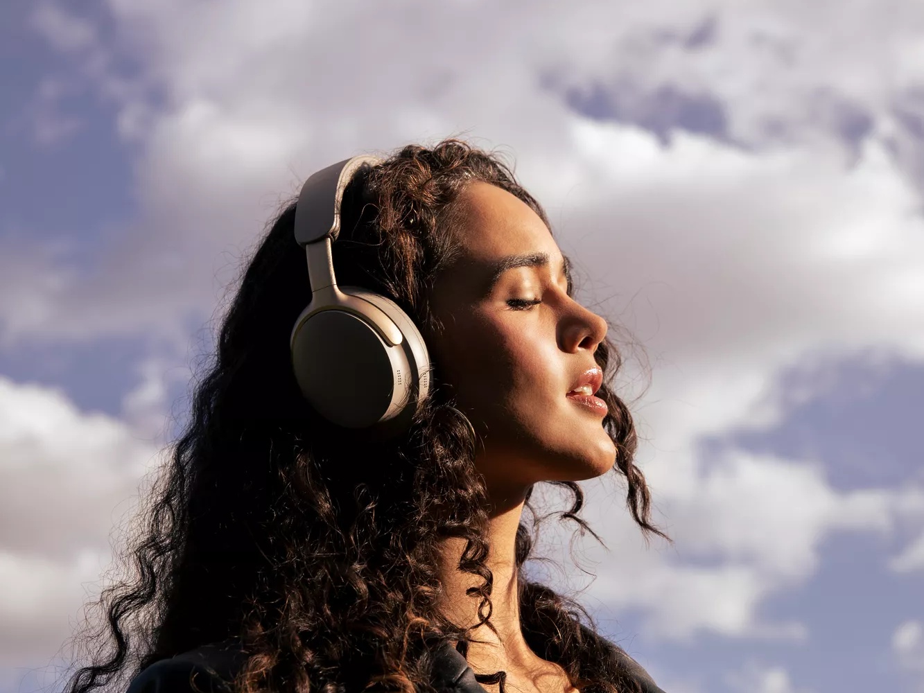 Woman enjoying peace and quiet from the noise cancellation of Bose QuietComfort Ultra Headphones