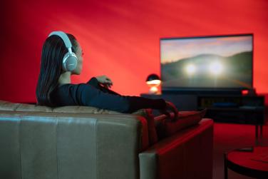 Woman watching movie with spatial audio from Bose QuietComfort Ultra Headphones