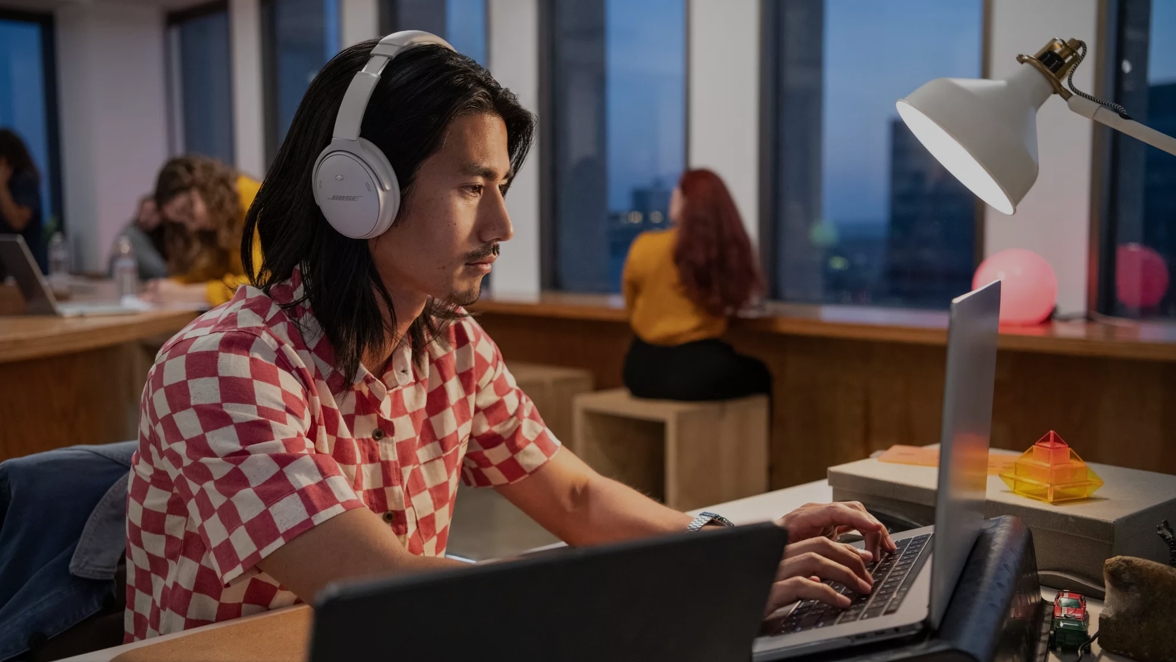 Man at work wearing Bose QuietComfort 45 Headphones