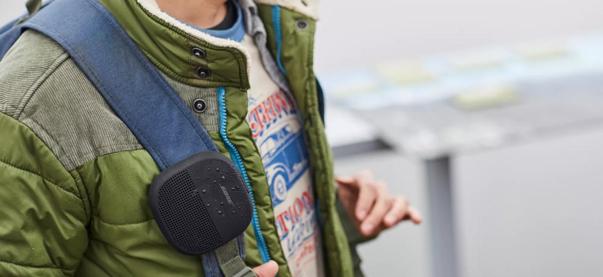 SoundLink Micro Bluetooth Speaker attached to the strap of a backpack 