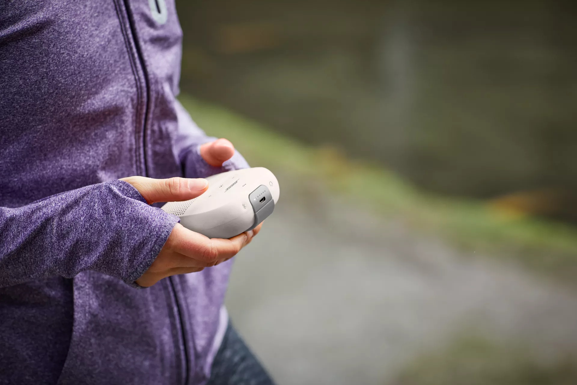 Femme tenant une enceinte Bose Bluetooth SoundLink Micro en marchant