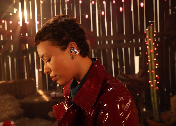 Woman wearing Bose Ultra Open Earbuds.